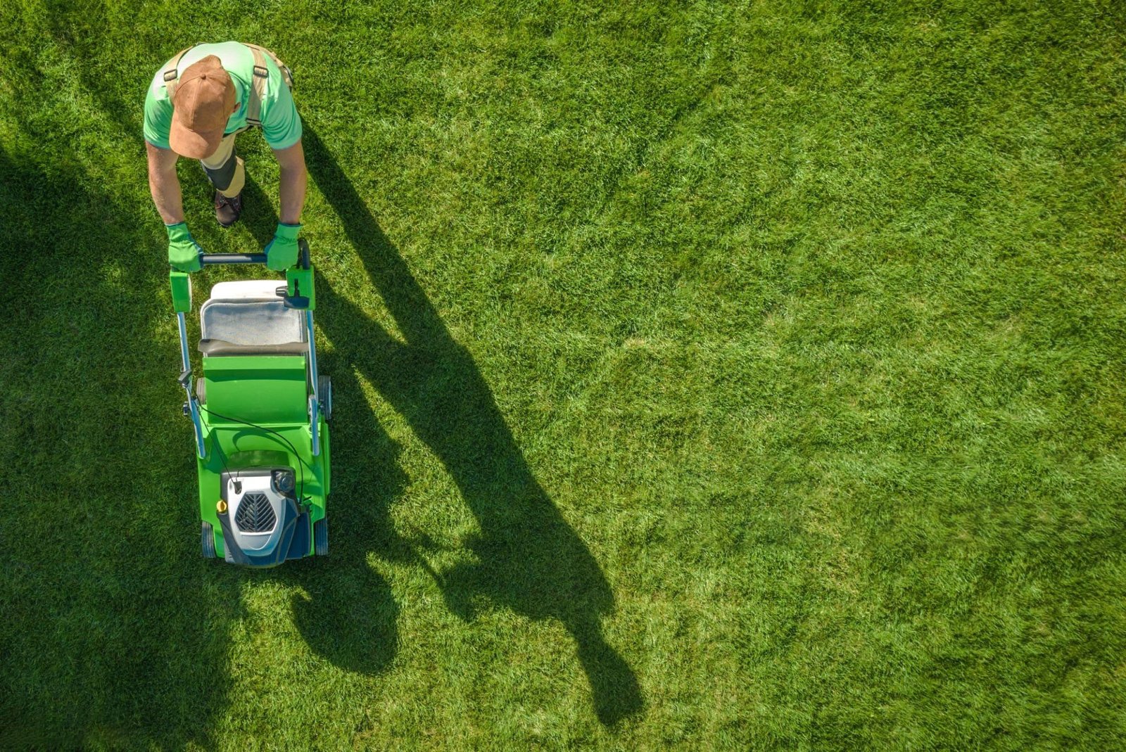 Lawn Moving Aerial Photo. Caucasian Gardener with Gasoline Grass Mower at Work. Landscaping Business. Industrial Theme.